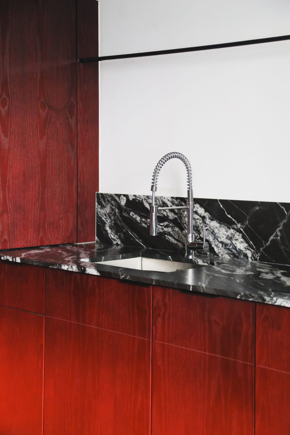 Kitchen detail, red lacquer and marble — sourced and directed by Setti